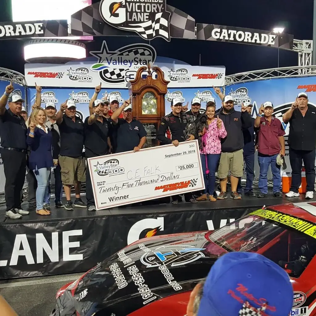 Team poses with trophy and giant check