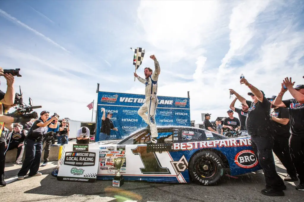 Winner celebrating on race car with flag
