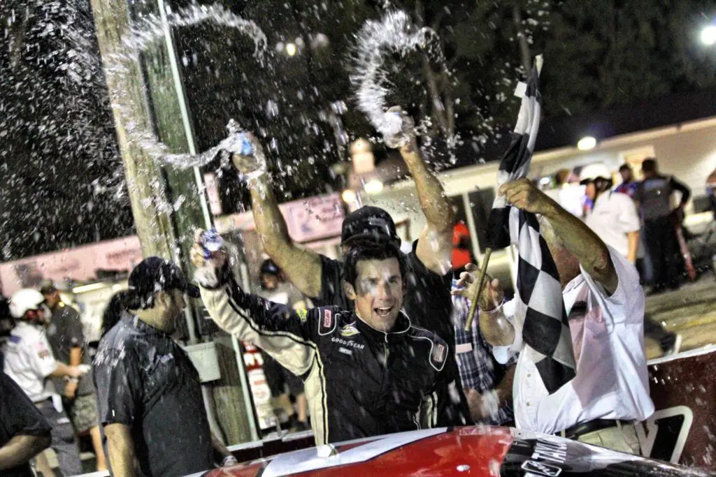 Celebration at racetrack with cheering crowd