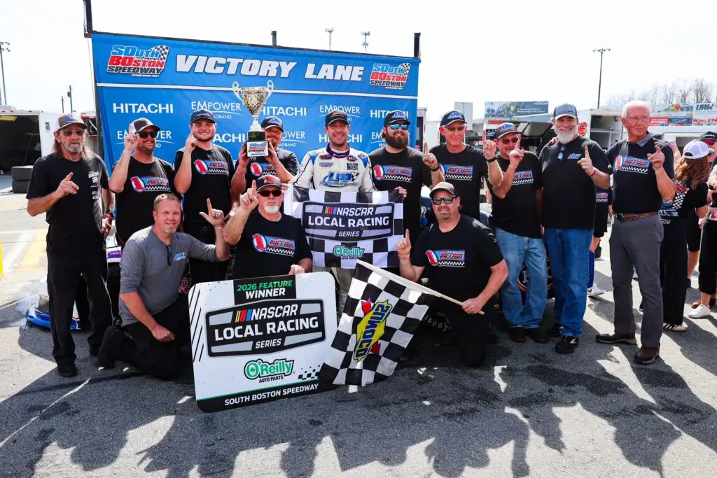 NASCAR team posing with checkered flag