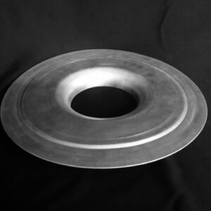 A metal object sitting on top of a black surface.