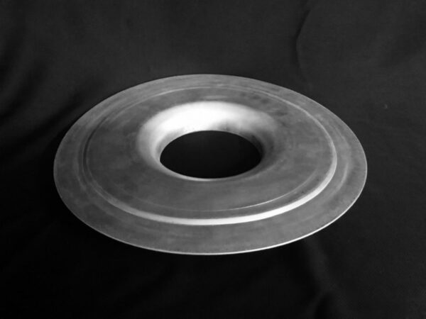 A metal object sitting on top of a black surface.