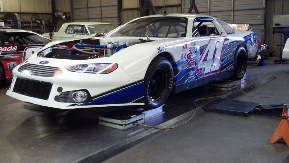 A white race car parked in the garage.