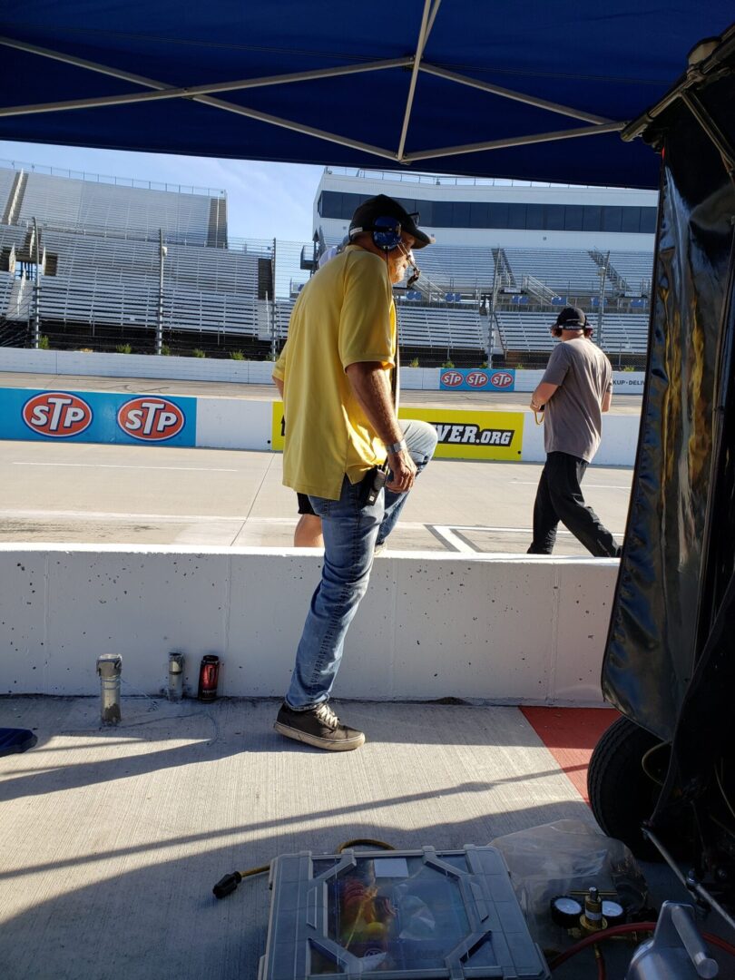 A man in yellow shirt holding a pole.