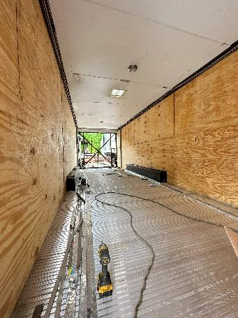 A long hallway with wood walls and flooring.