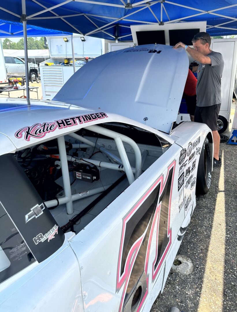 A man standing next to a race car.