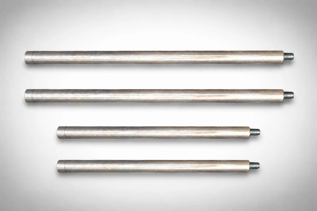 Set of four stainless steel rods on a gray background