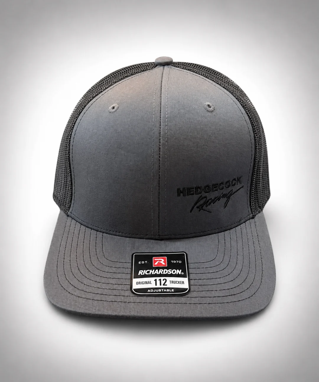 112 trucker hat with a black patch on the front, set against a white background
