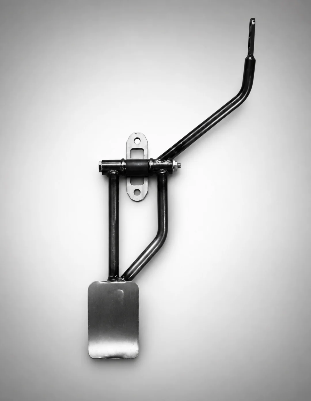 Black and white photo of a metal object, a shovel, on a white surface