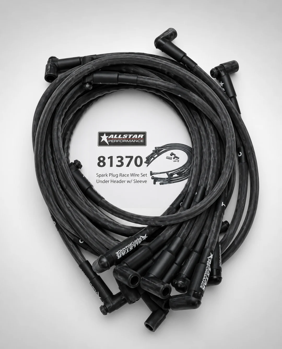 Set of black spark plug wires on a white background