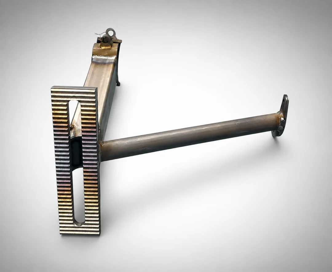 Metal object, a safety razor, on a white surface with a metal handle